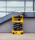 Cụm ổ cắm cấp nguồn có nắp đậy chống nước bố trí ngay trên sàn xe nâng người cắt kéo 7m JCB S1930E, giúp kết nối các thiết bị cầm tay an toàn khi làm việc trên cao.